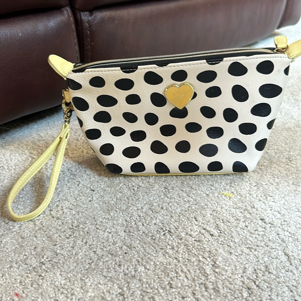Betsy Johnson wristlet with black polka dots and yellow wrist strap.